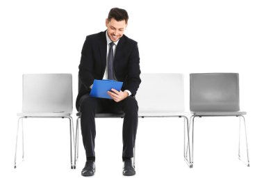 İş görüşmesi için beyaz arka plan üzerinde bekleyen genç adam