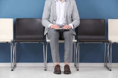 İş görüşmesi için kapalı bekleyen genç adam