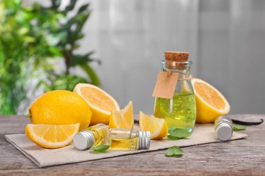 Uçucu yağlar ve ahşap masa üzerinde taze limon şişe