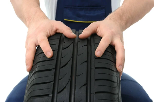 Mecânico masculino com pneu de carro no fundo branco, close-up — Fotografia de Stock