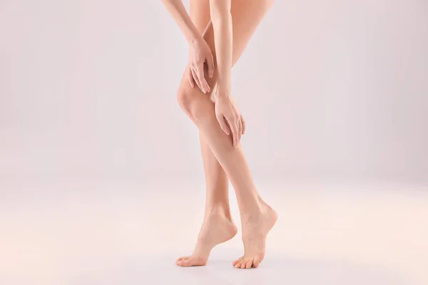 Mulher jovem com pele sedosa bonita no fundo leve, close-up de pernas — Fotografia de Stock