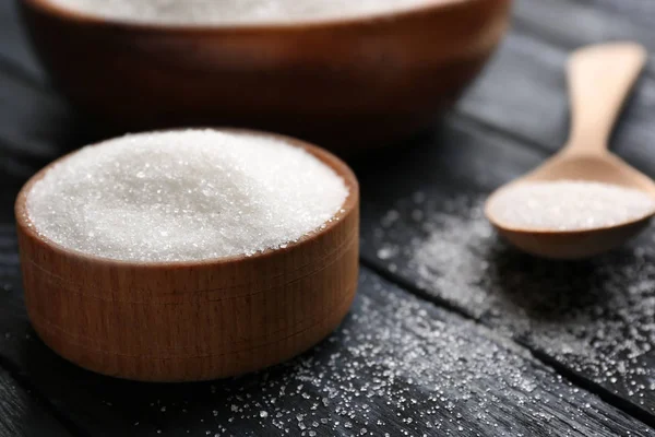 Kase ve saf şeker ahşap zemin üzerine kaşıkla