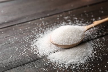 Ahşap arka plan üzerinde saf şeker kaşıkla