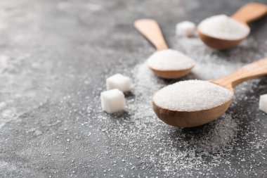 Gri arka plan üzerinde saf şeker kaşıklarla