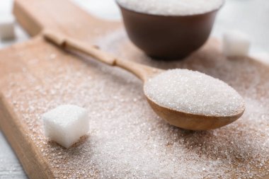 Ahşap tahta üzerinde saf şeker kaşıkla