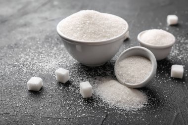 Gri arka plan üzerinde saf şeker ile seramik kaseler