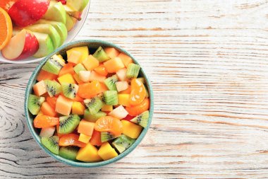 Ahşap masa, üstten görünüm üzerinde taze kesilmiş meyve ile kase