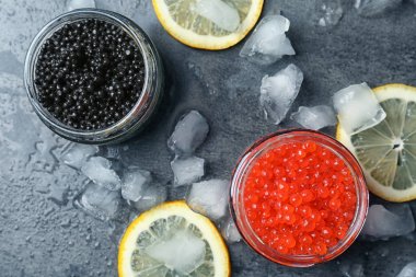 Cam Kavanoz gri arka plan üzerinde siyah ve kırmızı havyar ile