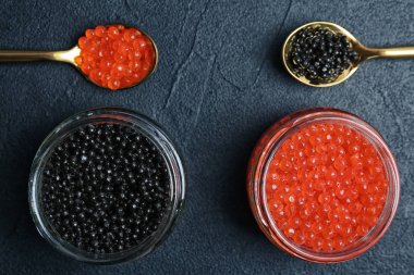 Cam Kavanoz ve metal kaşık gri arka plan üzerinde siyah ve kırmızı havyar ile