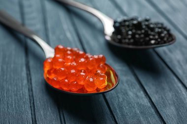 Metal kaşık ahşap arka plan üzerinde siyah ve kırmızı havyar ile