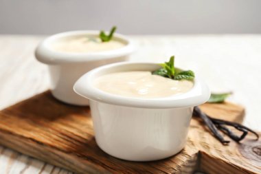 Vanilya puding, sopa ve ahşap tahta üzerinde taze nane