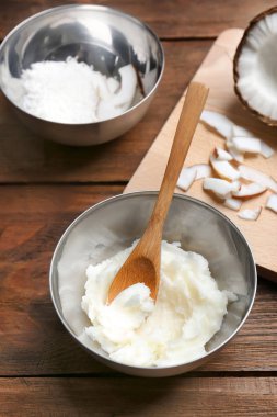 Hindistan cevizi yağı ve fındık pul ahşap arka plan üzerinde kaseler