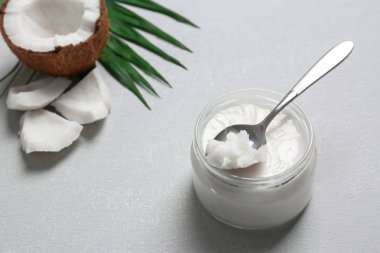 Hindistan cevizi yağı ve fındık adet gri arka plan üzerine kavanoz