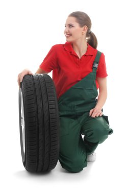 Beyaz arka plan üzerinde otomobil lastiği ile kadın makinist