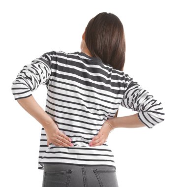 Beyaz arka planda sırt ağrısı çeken genç bir kadın.