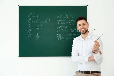 Erkek öğretmen sınıfta blackboard yakınındaki portresi