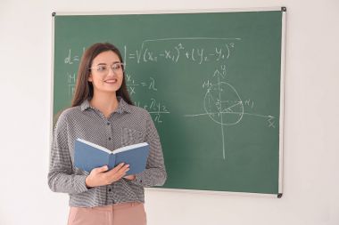 Kitap konumu blackboard sınıfta yakın olan kadın öğretmen