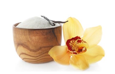 Çiçek ve beyaz arka plan üzerinde sopa kase vanilya şekeri