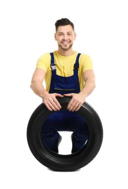 Beyaz arka plan üzerinde otomobil lastiği ile erkek makinist