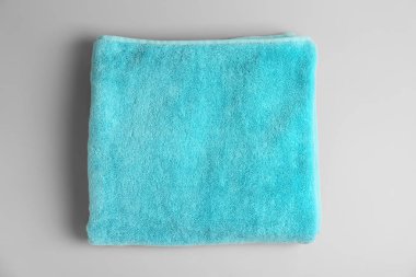 Yumuşak banyo havlusu gri arka planda, üstten görünüm