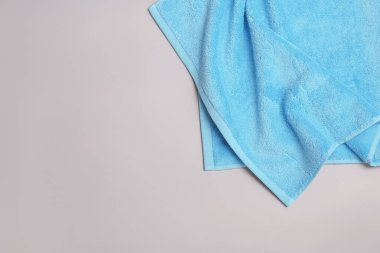 Yumuşak banyo havlusu gri arka planda, üstten görünüm