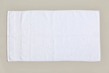 Yumuşak banyo havlusu gri arka planda, üstten görünüm