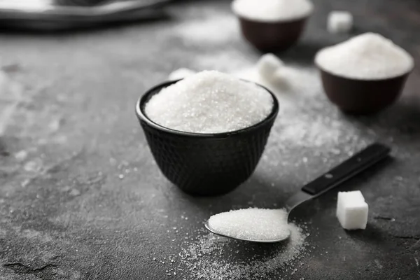 Ciotola e cucchiaio con zucchero puro su fondo grigio — Foto Stock