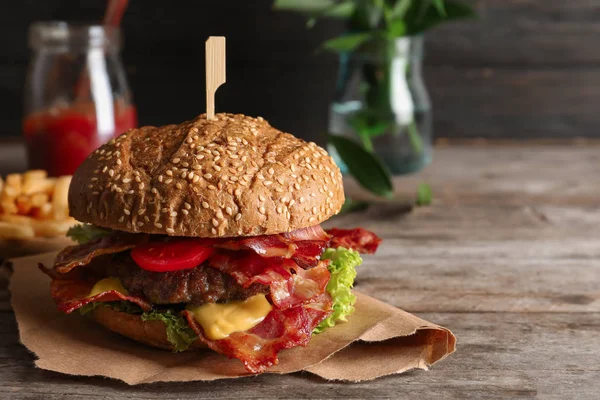 Chutné burger se slaninou na dřevěný stůl — Stock fotografie
