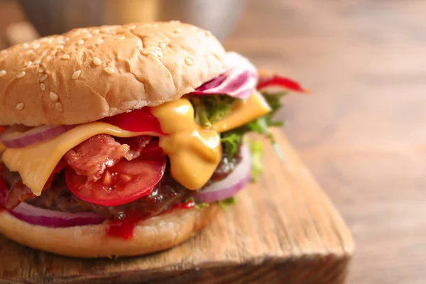 Hambúrguer saboroso com bacon na placa de madeira — Fotografia de Stock