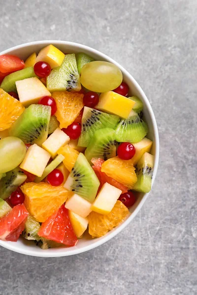 Miska z sałatki ze świeżych owoców na szarym tle — Zdjęcie stockowe