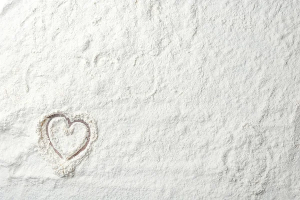 Heart drawing on white wheat flour, closeup