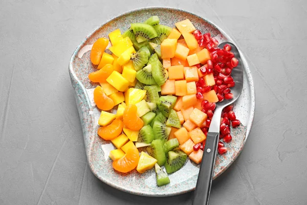 Plate with fresh cut fruits on table, top view