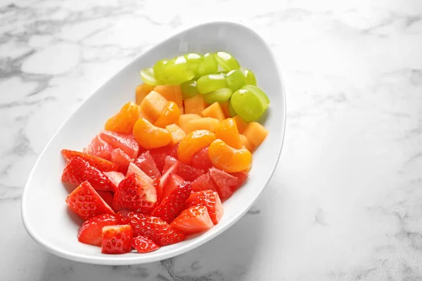 Piatto con frutta fresca tagliata in tavola — Foto Stock