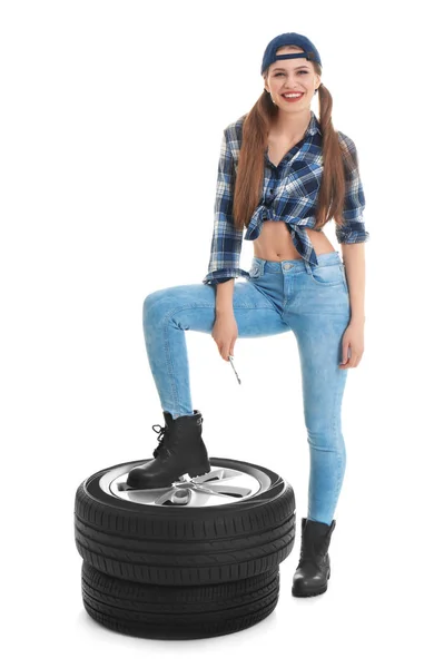 Jeune femme en tenue séduisante avec des pneus de voiture sur fond blanc — Photo