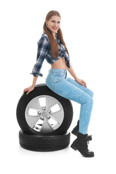 Молодая женщина в соблазнительном наряде с автомобильными шинами на белом фоне — стоковое фото