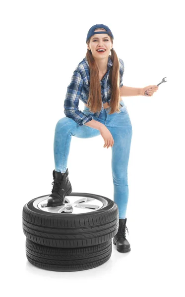 Mladá žena v svůdné oblečení s auto pneumatiky na bílém pozadí — Stock fotografie