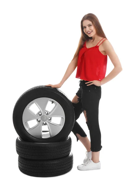 Jovem mulher em roupa sedutora com pneus de carro no fundo branco — Fotografia de Stock