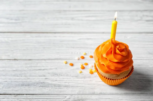 Delicioso cupcake de cumpleaños con vela encendida en la mesa —  Fotos de Stock