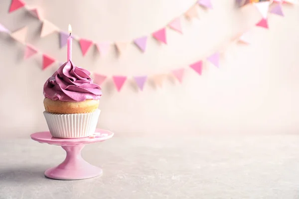 Delizioso cupcake di compleanno con candela accesa sul tavolo — Foto Stock