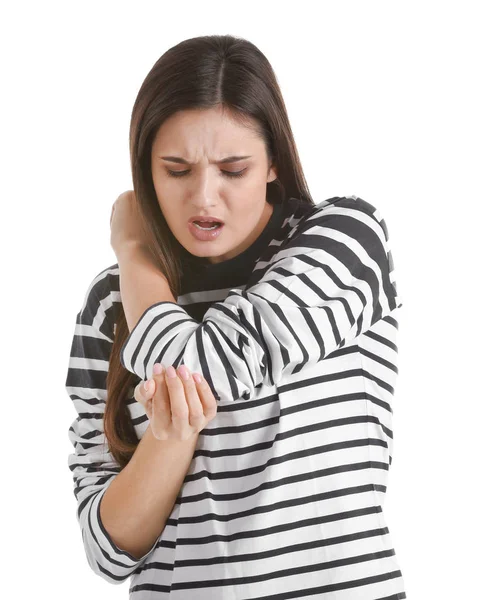 Mujer joven que sufre de dolor de codo sobre fondo blanco —  Fotos de Stock