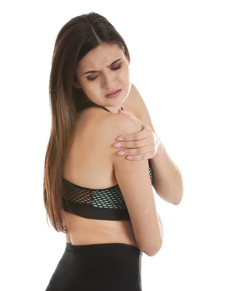 Mujer joven que sufre de dolor de hombro sobre fondo blanco —  Fotos de Stock