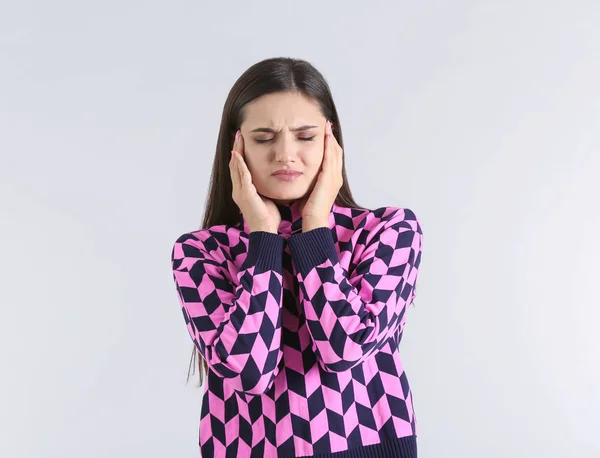 Jonge vrouw met hoofdpijn op lichte achtergrond — Stockfoto
