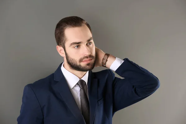 Retrato de joven empresario con hermoso pelo sobre fondo gris — Foto de Stock