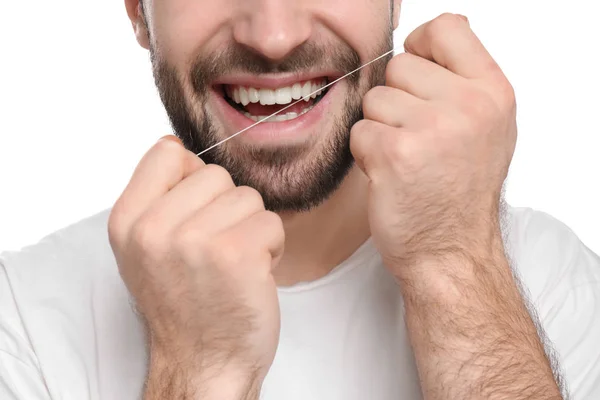 Jovem homem fio dental seus dentes no fundo branco — Fotografia de Stock