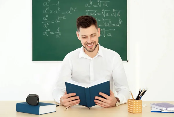 Professor do sexo masculino que trabalha à mesa em sala de aula — Fotografia de Stock