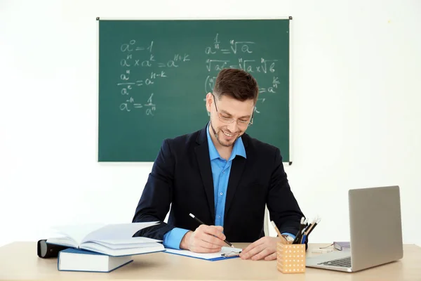 Professeur masculin travaillant à table en classe — Photo