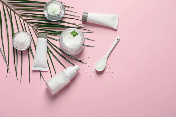 Diferentes productos cosméticos para el cuidado de la piel con hoja verde sobre fondo de color, vista superior — Foto de Stock