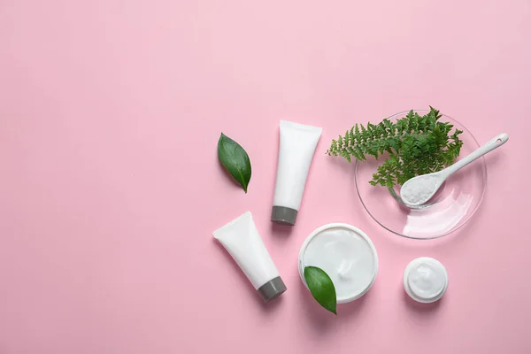 Farklı cilt bakımı kozmetik ürünleri renk arka plan, üstten görünüm üzerinde yeşil yaprakları ile — Stok fotoğraf