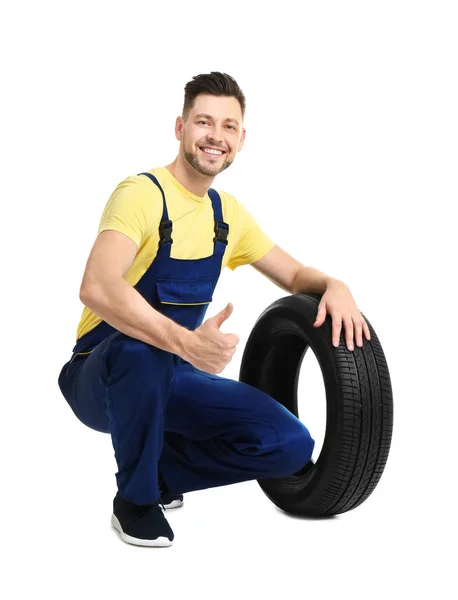 Manliga mekaniker med bildäck på vit bakgrund — Stockfoto