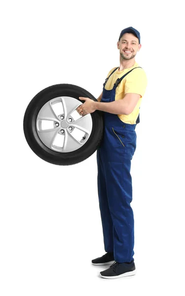 Чоловічий механік з автомобільною шиною на білому тлі — стокове фото